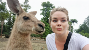 En turism- och resekonsult fångar en selfie med en känguru i en lummig utomhusmiljö, blandar arbete med äventyr och skapar minnen.