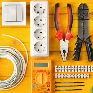YH Akademins yrkesutbildning: Elektriker-verktyg och utrustning på gult bord.