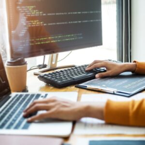 YH Akademins distansutbildningar: programmerare kodar vid datorstation.