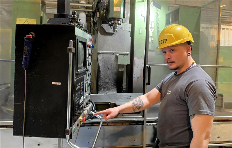 Man i gul skyddshjälm som manövrerar en kontrollpanel i en industrimiljö där ny utbildning ska möta kompetensbristen på fog- och brandtätare.